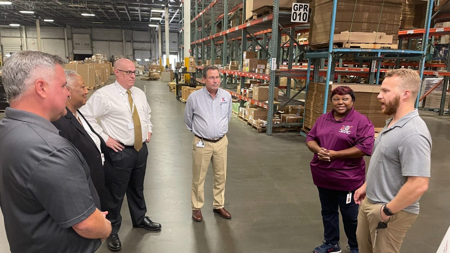 <b>Dan Daniel Distribution Center Fashion Managers Nona Capel and Zachary Cox, right, talk with John Stoneburg (in tie), John Stoneburg, Deputy Assistant Secretary of the Army (Military Personnel & Quality of Life) during Stoneburg's tour of the DC. Also pictured, from left, are DC Manager David Hill; Philanda Morgan, the Exchange’s Department of Defense liaison officer; and Executive Vice President/Chief Logistics Officer Alan French.</b>