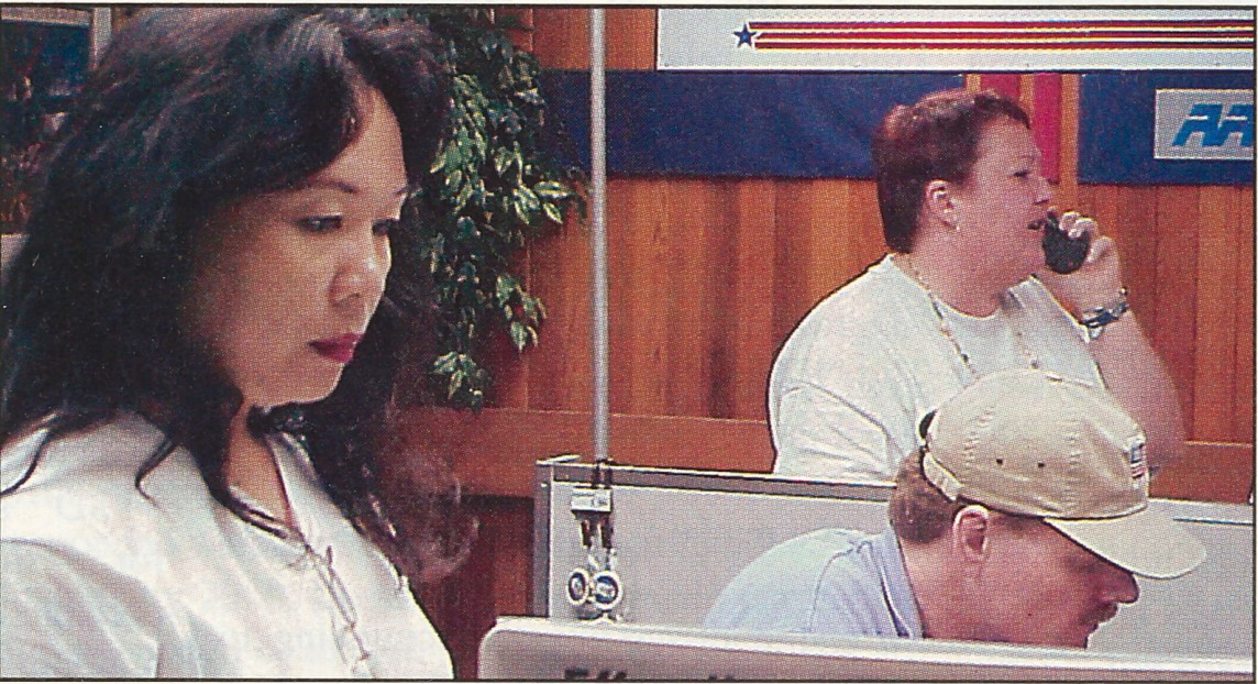 <b>Pictured above in a March 2000 Exchange Post photo are, from left, three Operation First Light team members: Tess Miguel, Guam Military Clothing store manager; Brian Lawrence, HQ-IS (now IT)); and Sylvia Scott, Guam data processing manager. Scott and Lawrence led local managers through a system checklist and provided detailed feedback to HQ. </b>