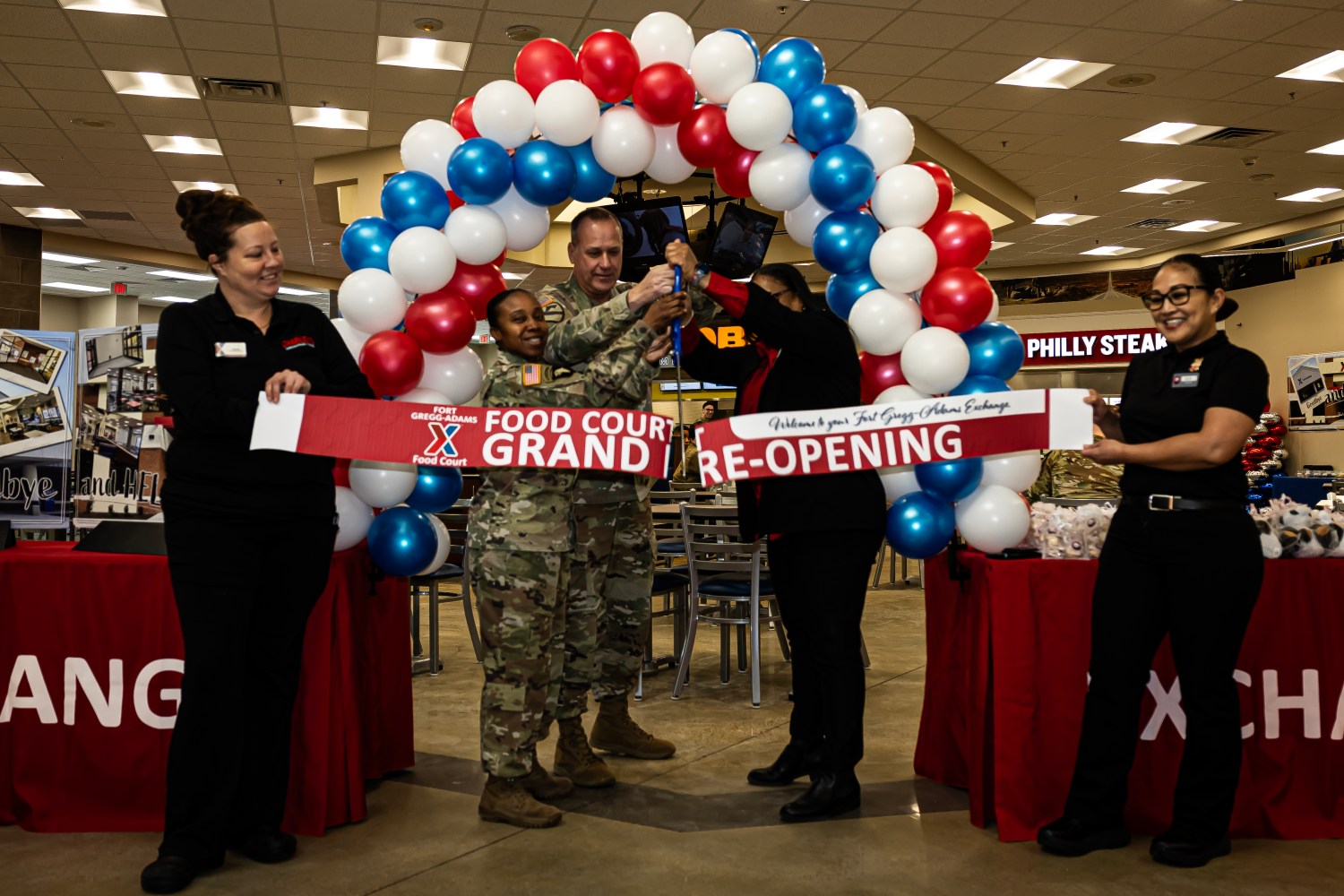 <b>Exchange General Manager Lajima Marshall-Pierce (center-right), Fort Gregg-Adams Senior Command Chaplain Col. Tom Allen (center), and Command Sgt. Maj. Sheila Parrish (center-left) cut the grand re-opening ribbon to an expanded food court Jan. 15, 2025, at the Main Exchange’s entrance at Fort Gregg-Adams, Va. The food court now features more than double the previous seating capacity—from 122 to 272 seats. (U.S. Army photo by Chad Menegay)